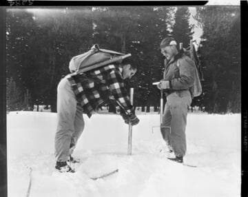 Big Creek snow survey.  Close up of men forcing snow